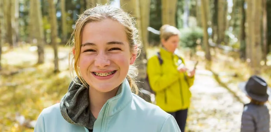 Teenage girl with braces smiling on a bushwalk