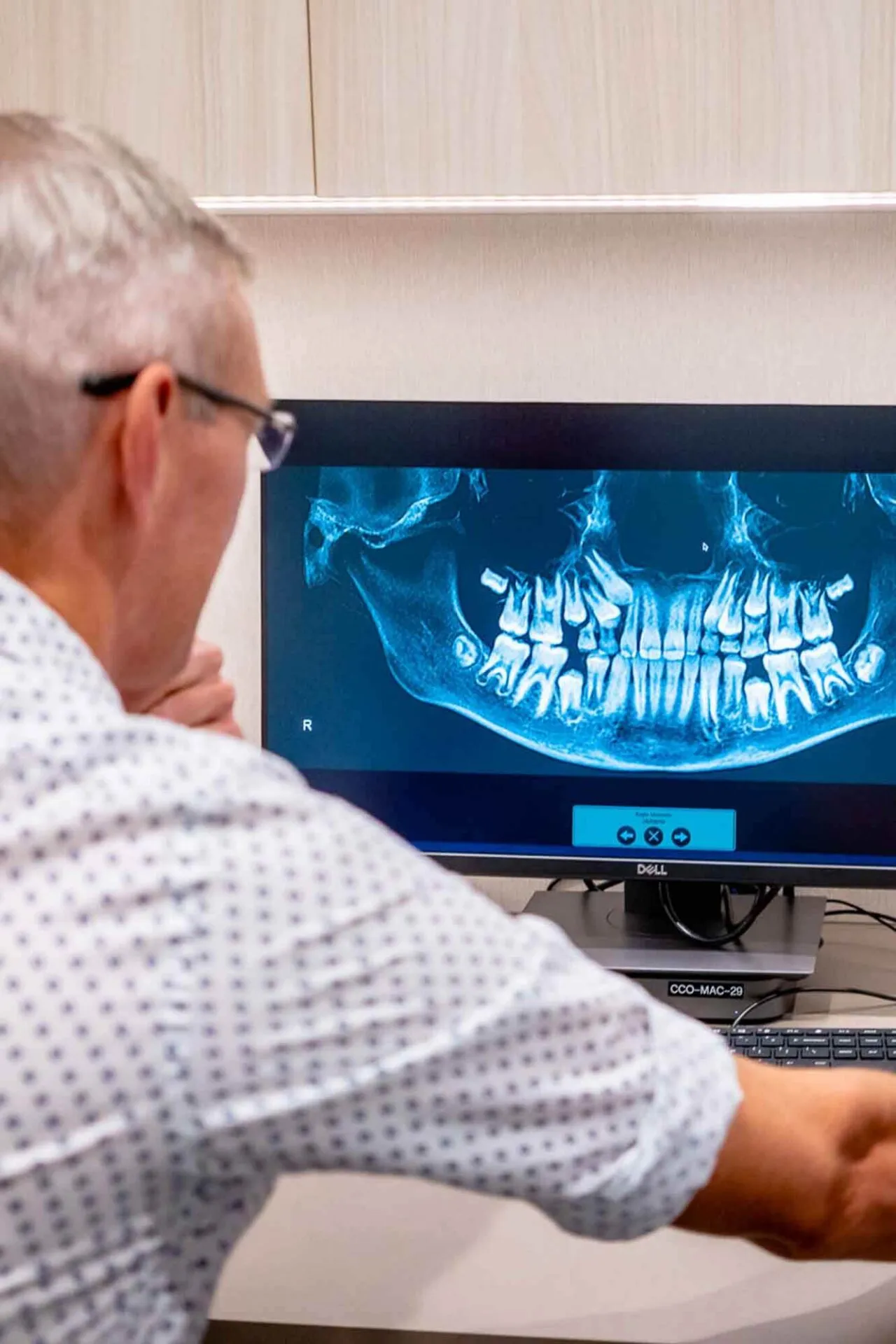 Orthodontist studying a patient's panoramic jaw x-ray on a screen