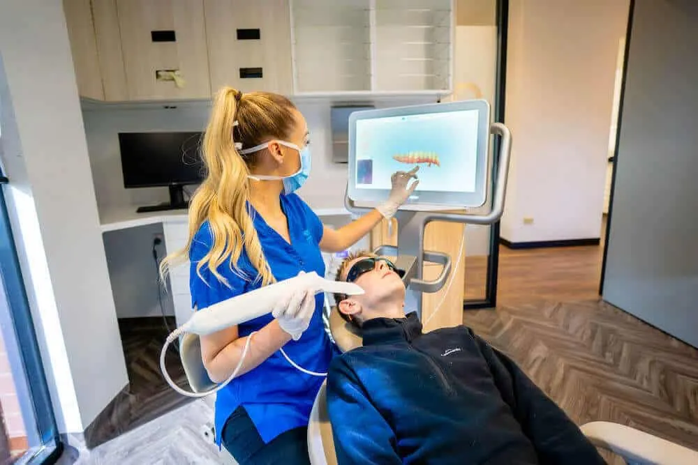 Dental assistant taking a digital scan of a patient's teeth in the treatment room