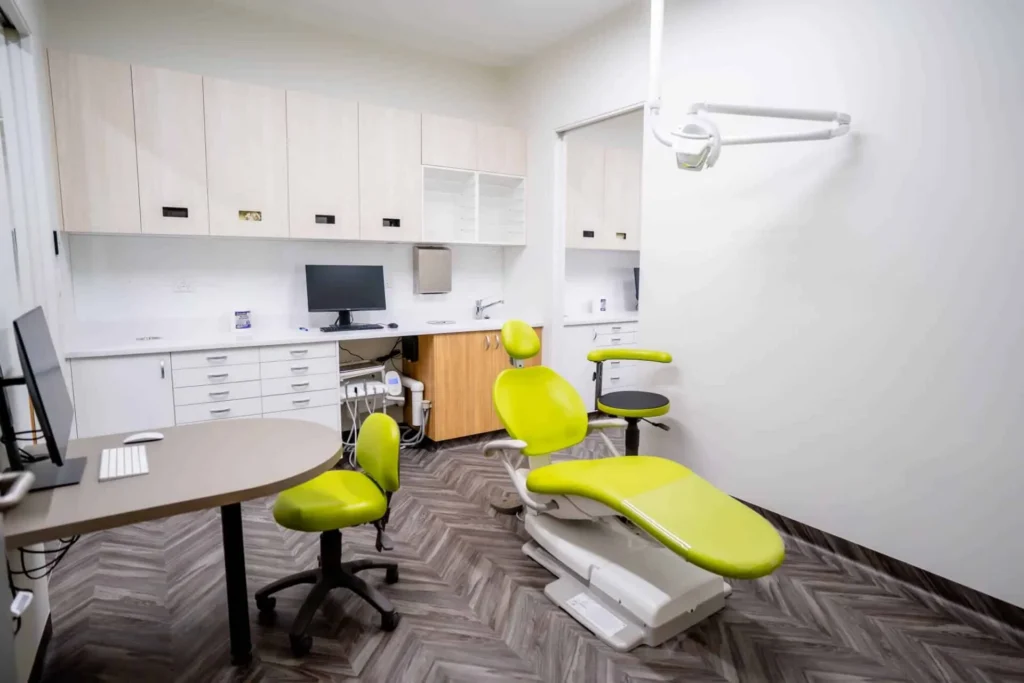 Treatment room at Central Coast Orthodontics with a lime-green dental chair and wall cabinetry
