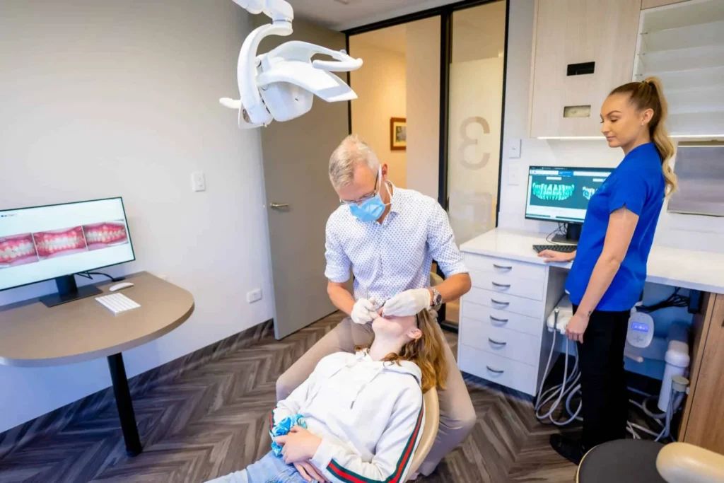 Orthodontist and dental assistant treating a patient in the chair