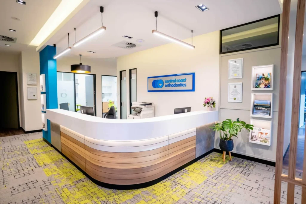 Reception desk at Central Coast Orthodontics with the practice signage behind it