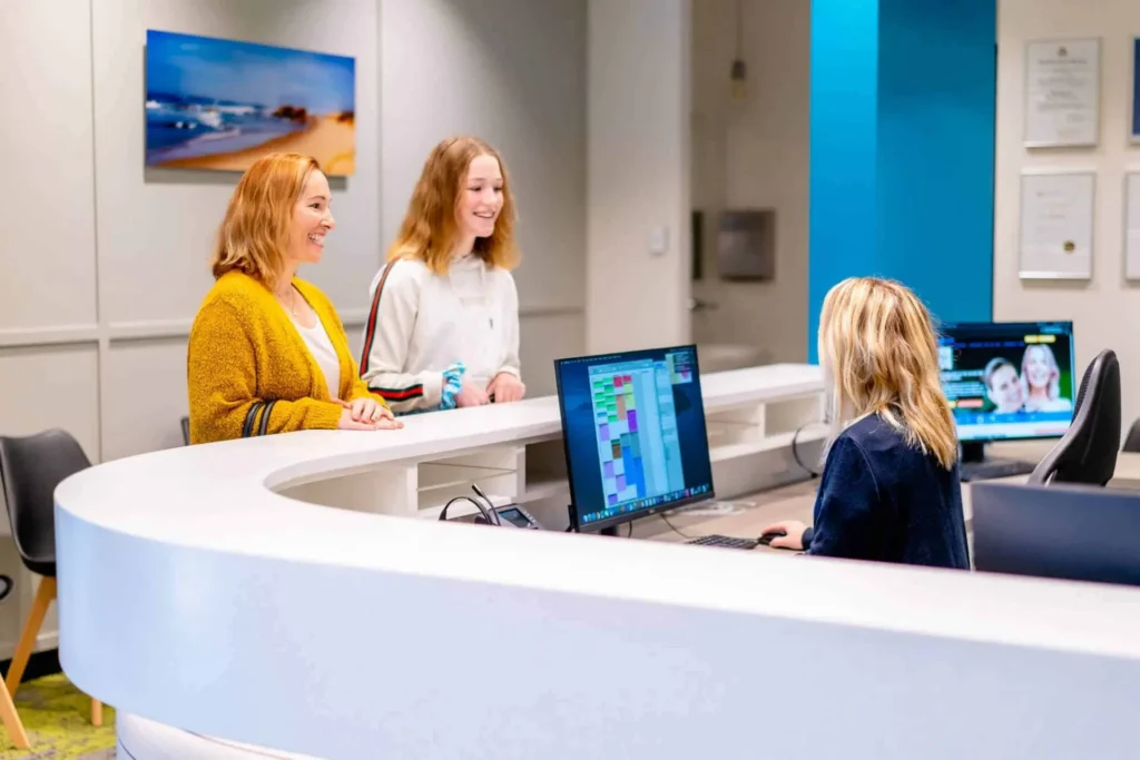 Parent and teenage patient at the reception desk of Central Coast Orthodontics in Erina