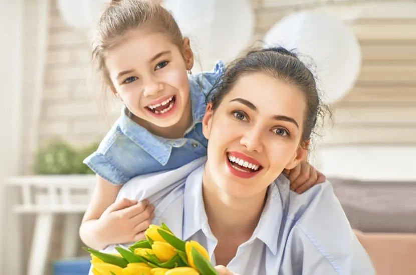 Smiling girl with braces hugging her mother