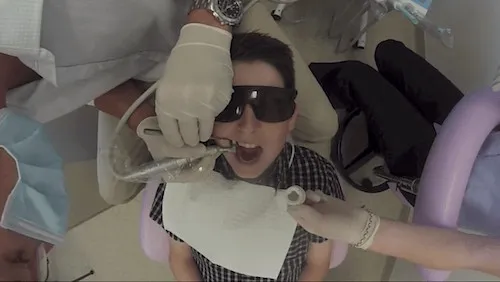 Patient in protective glasses having braces fitted, seen from above