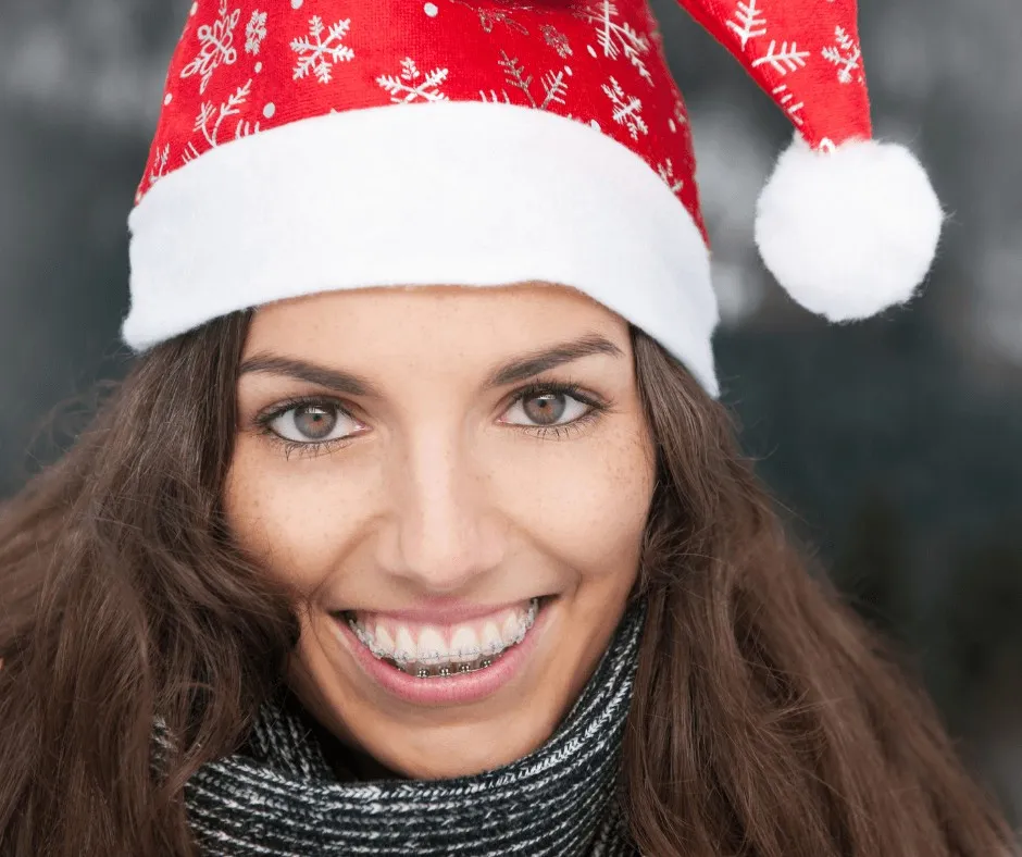 Woman in a Santa hat smiling outdoors