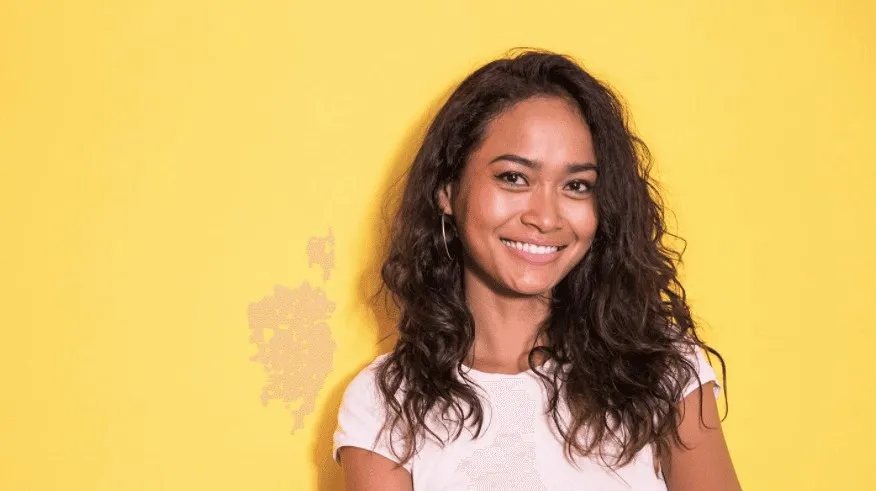 Smiling young woman against a yellow background