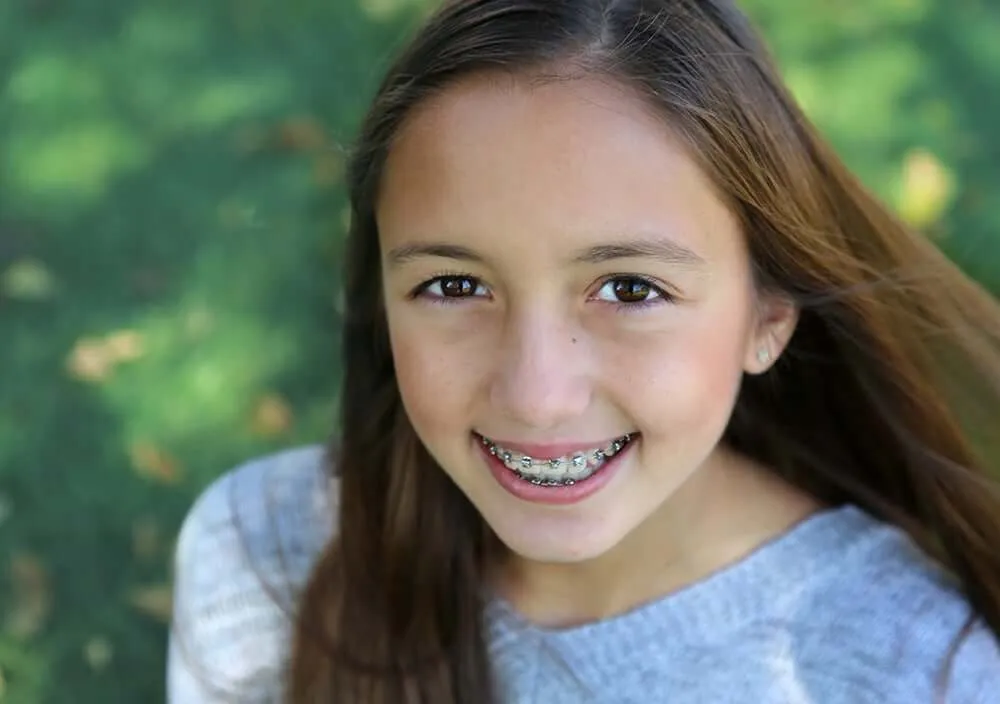 Girl with braces smiling outdoors