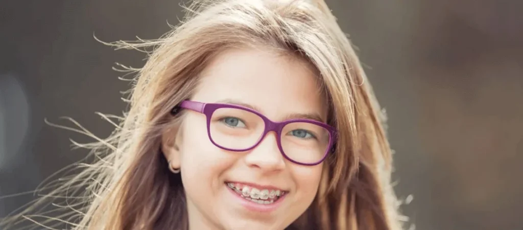 Young girl in glasses smiling with braces