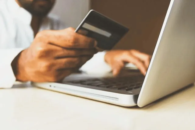 Person entering card details on a laptop to make a payment