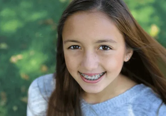 Girl with braces smiling outdoors